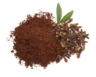 Pile of clove powder, dried buds and green leaves on white background, top view. Aromatic spice