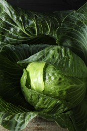 Photo of One ripe head of cabbage on wooden table, closeup