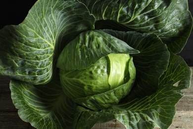 Photo of One ripe head of cabbage on wooden table, closeup