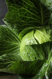 Photo of One ripe head of cabbage on wooden table, closeup