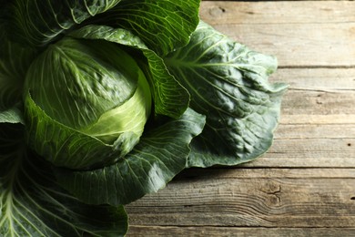 One ripe head of cabbage on wooden table, closeup