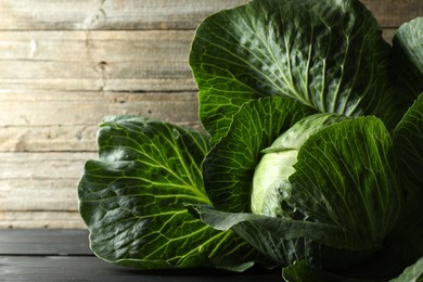 Photo of One ripe head of cabbage on wooden table, closeup