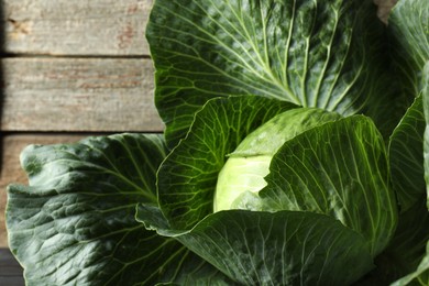 Photo of One ripe head of cabbage on wooden background, closeup