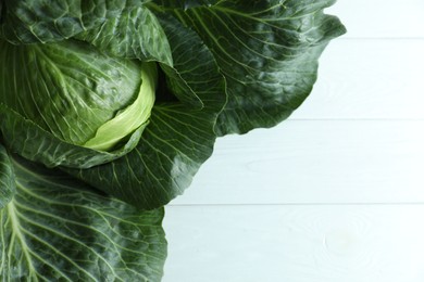 Photo of One ripe head of cabbage on white wooden table, top view. Space for text