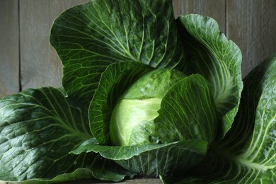 One ripe head of cabbage on wooden table, closeup