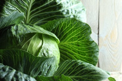 One ripe head of cabbage against wooden background, closeup