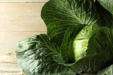 Photo of One ripe head of cabbage on wooden table, closeup