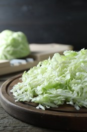 Photo of Fresh shredded cabbage on wooden table, closeup