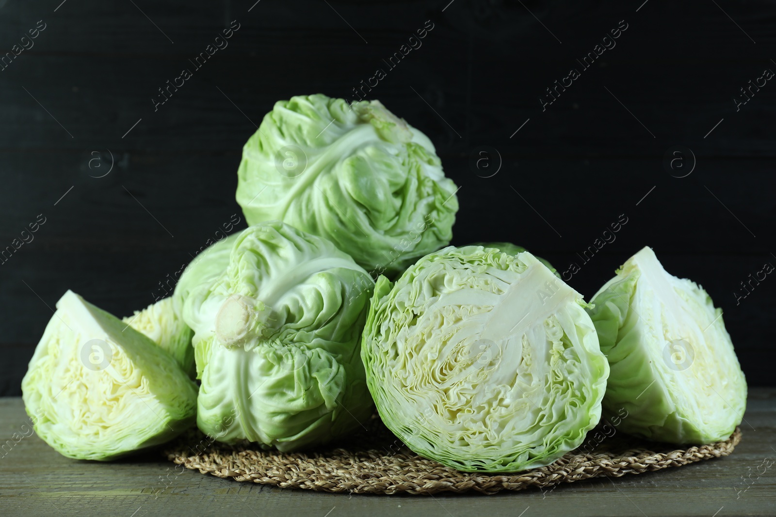 Photo of Whole and cut fresh cabbages on wooden table