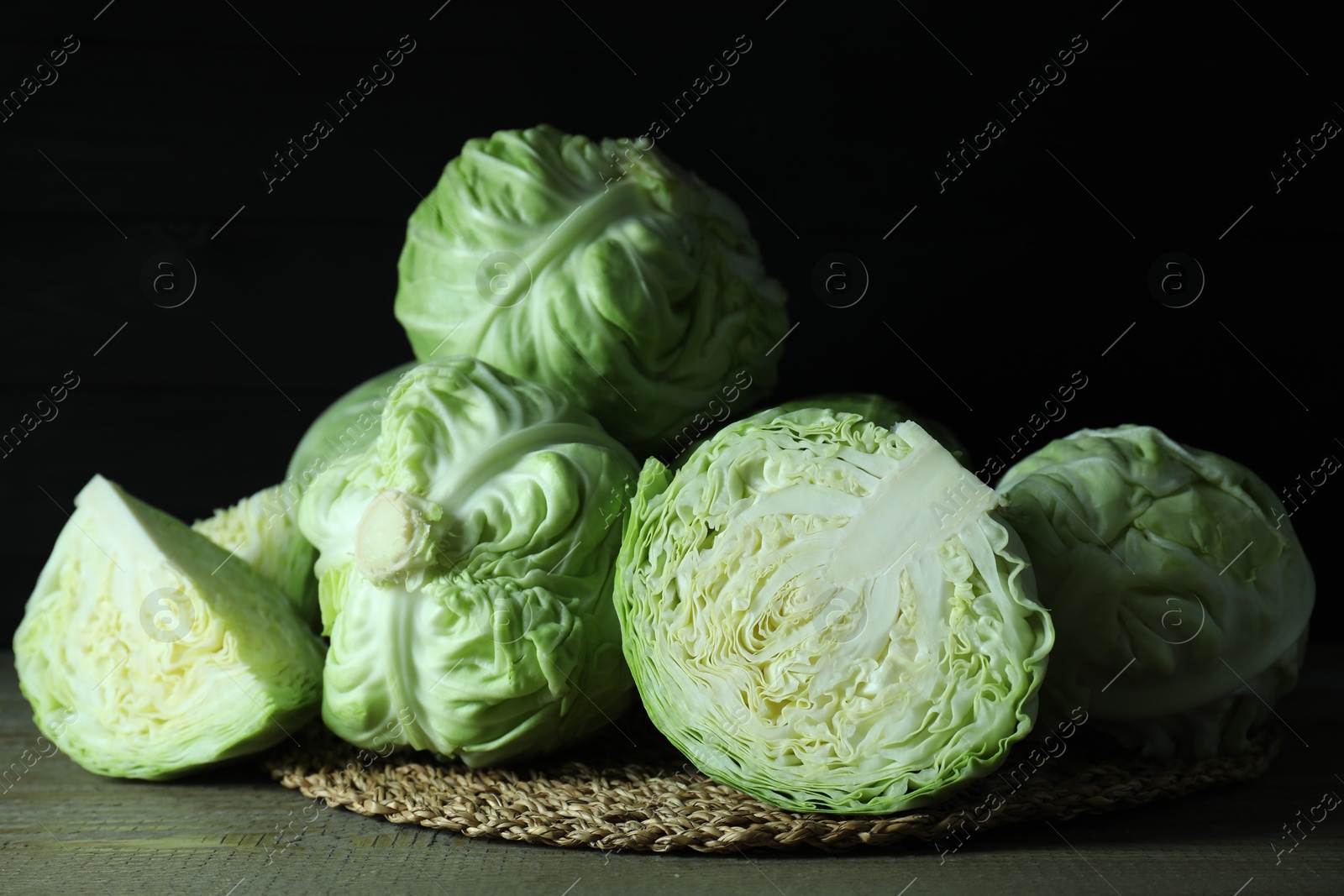 Photo of Whole and cut fresh cabbages on wooden table