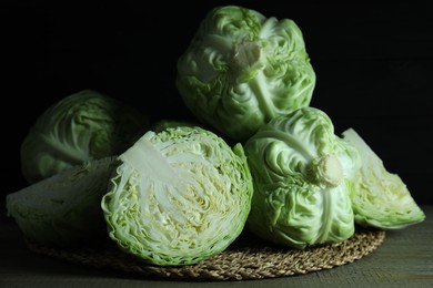 Photo of Whole and cut fresh cabbages on wooden table