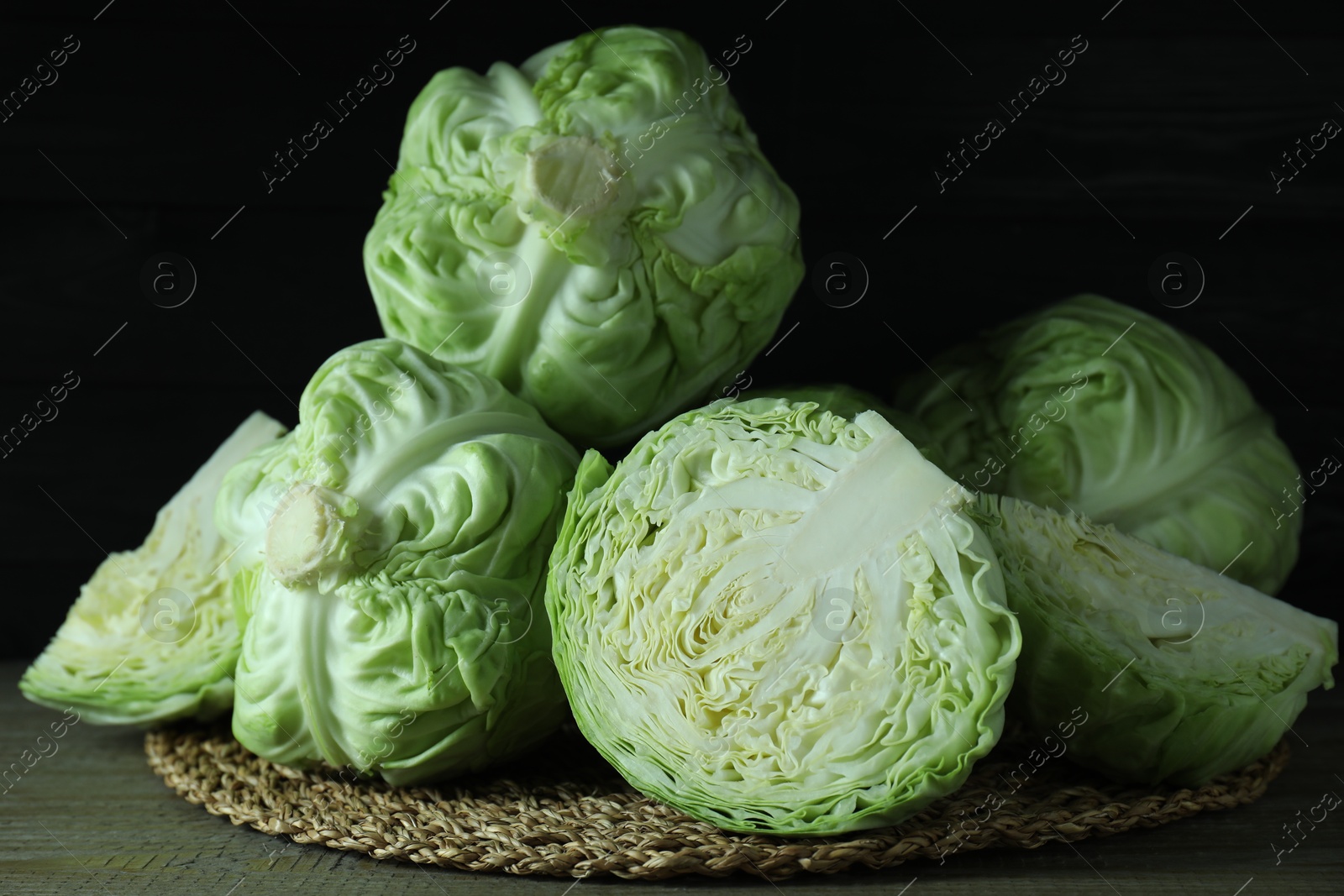 Photo of Whole and cut fresh cabbages on wooden table