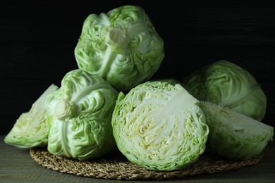 Photo of Whole and cut fresh cabbages on wooden table