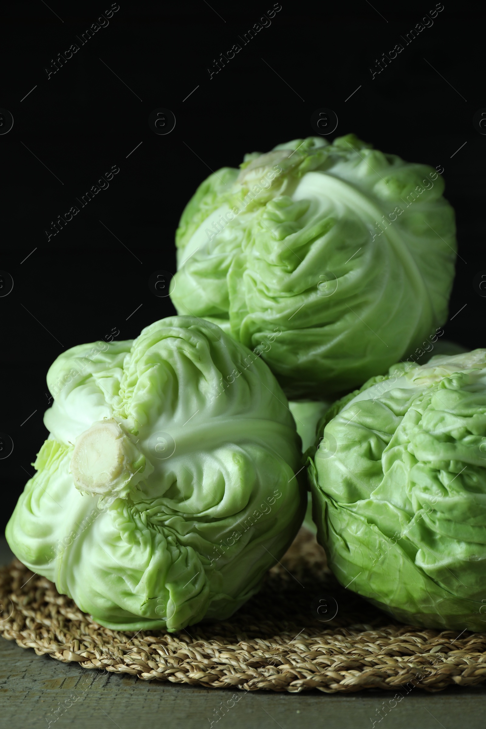 Photo of Three heads of cabbage on wooden table, closeup