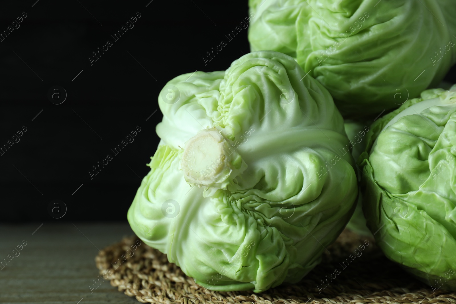 Photo of Three heads of cabbage on wooden table, closeup