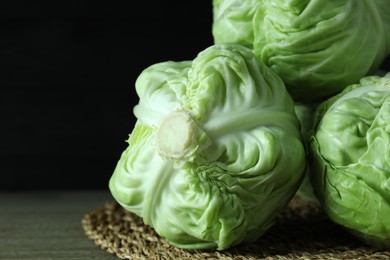 Photo of Three heads of cabbage on wooden table, closeup