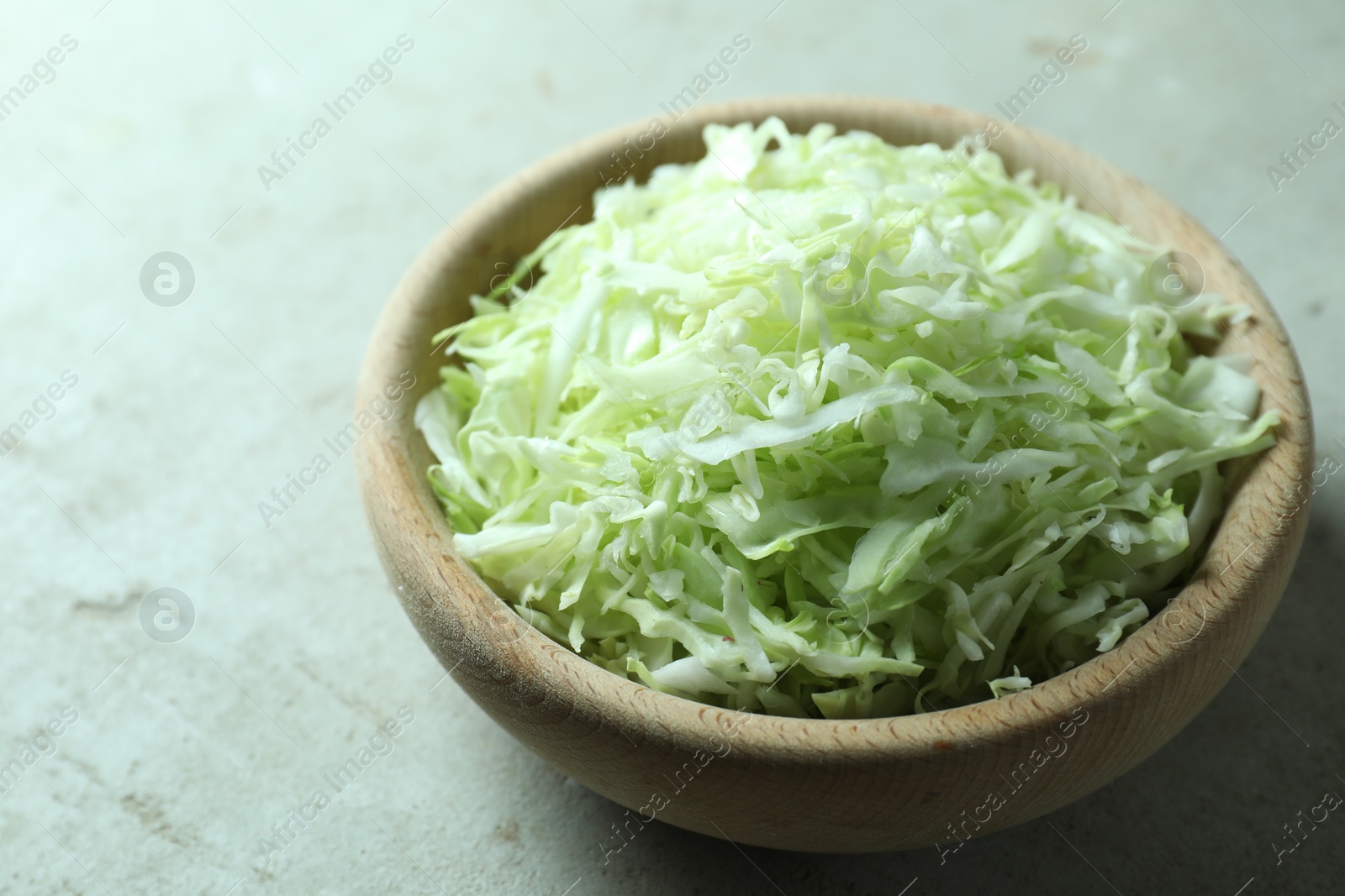 Photo of Fresh shredded cabbage on light table, closeup