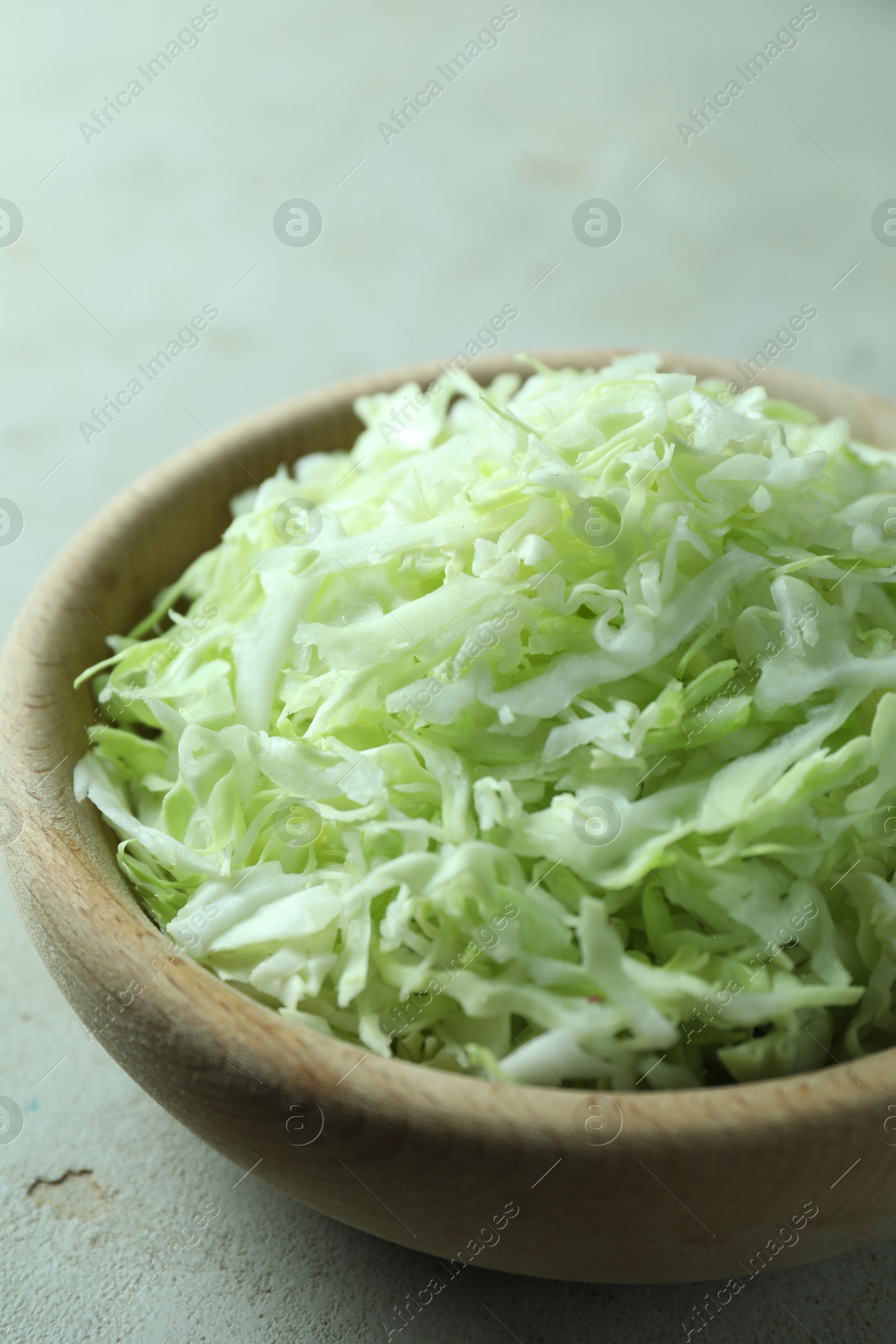 Photo of Fresh shredded cabbage on light table, closeup