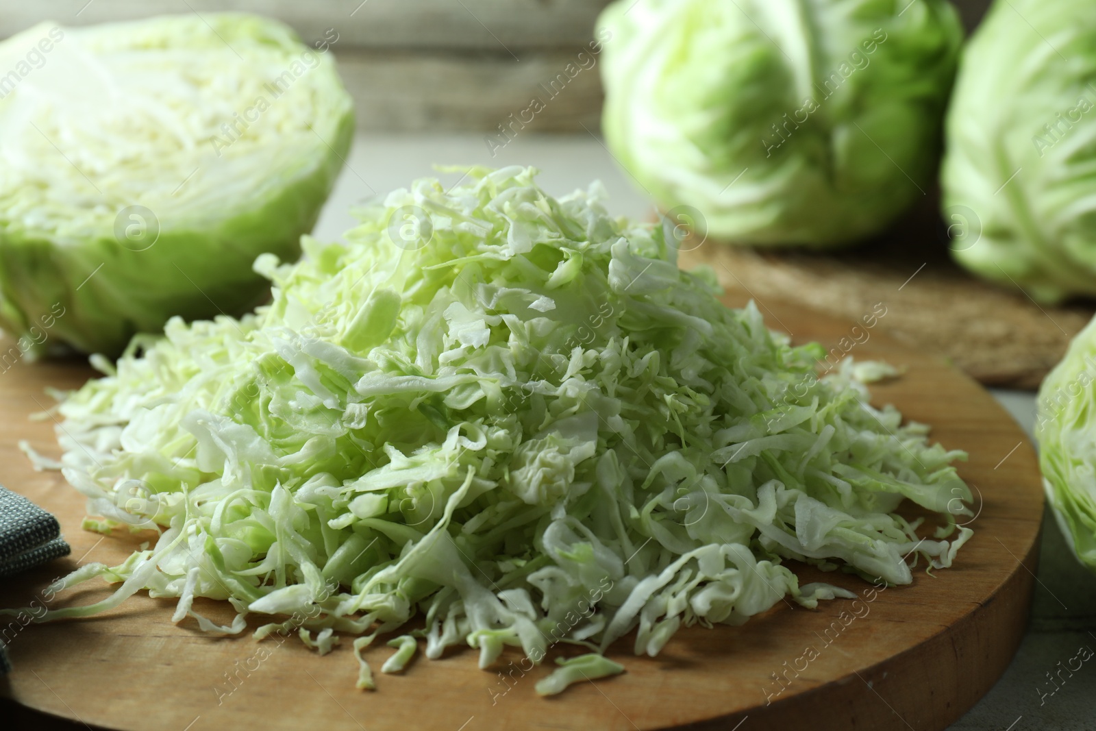 Photo of Fresh shredded cabbage on wooden board, closeup