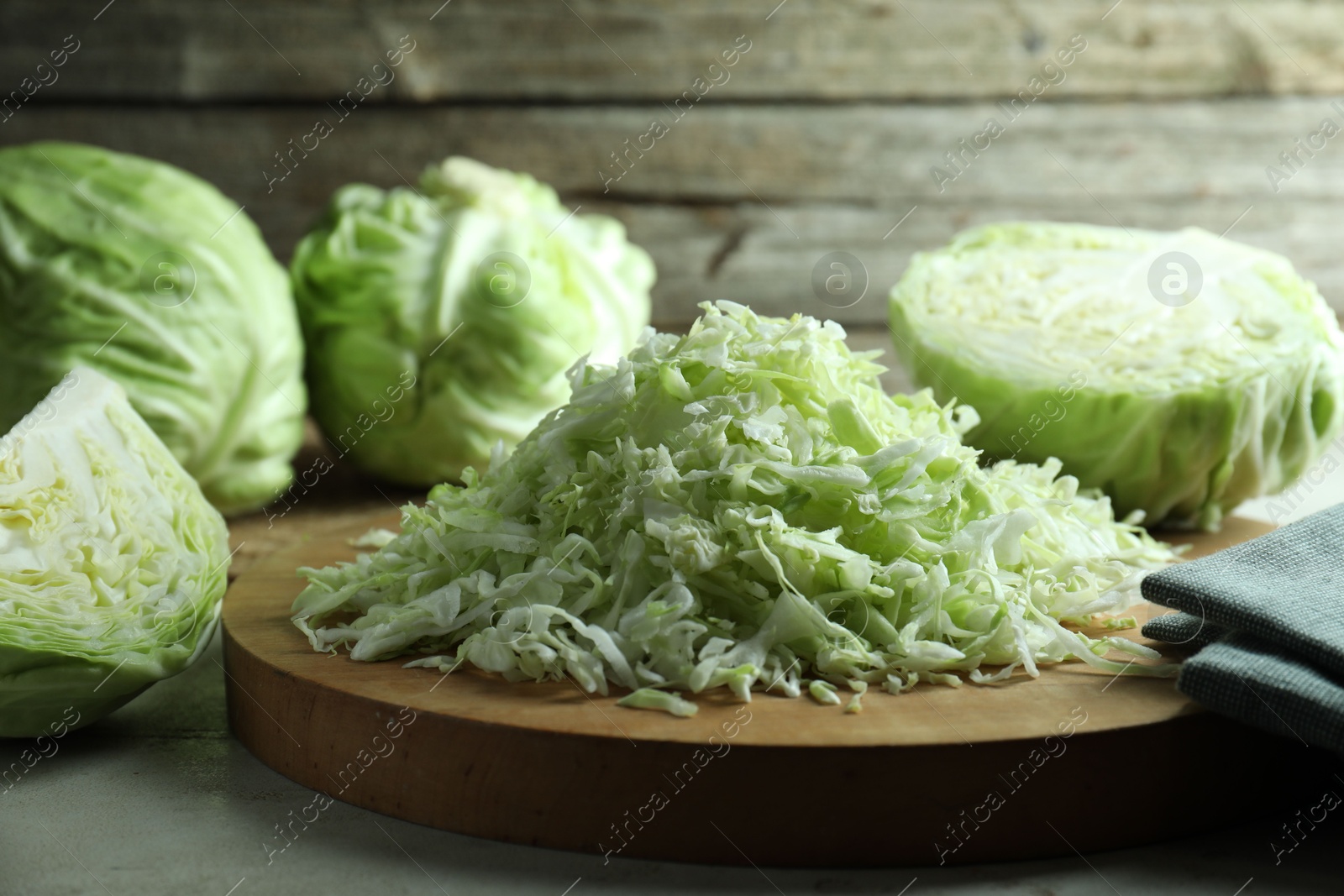 Photo of Fresh shredded cabbage on light table, closeup