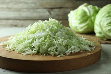 Photo of Fresh shredded cabbage on light table, closeup