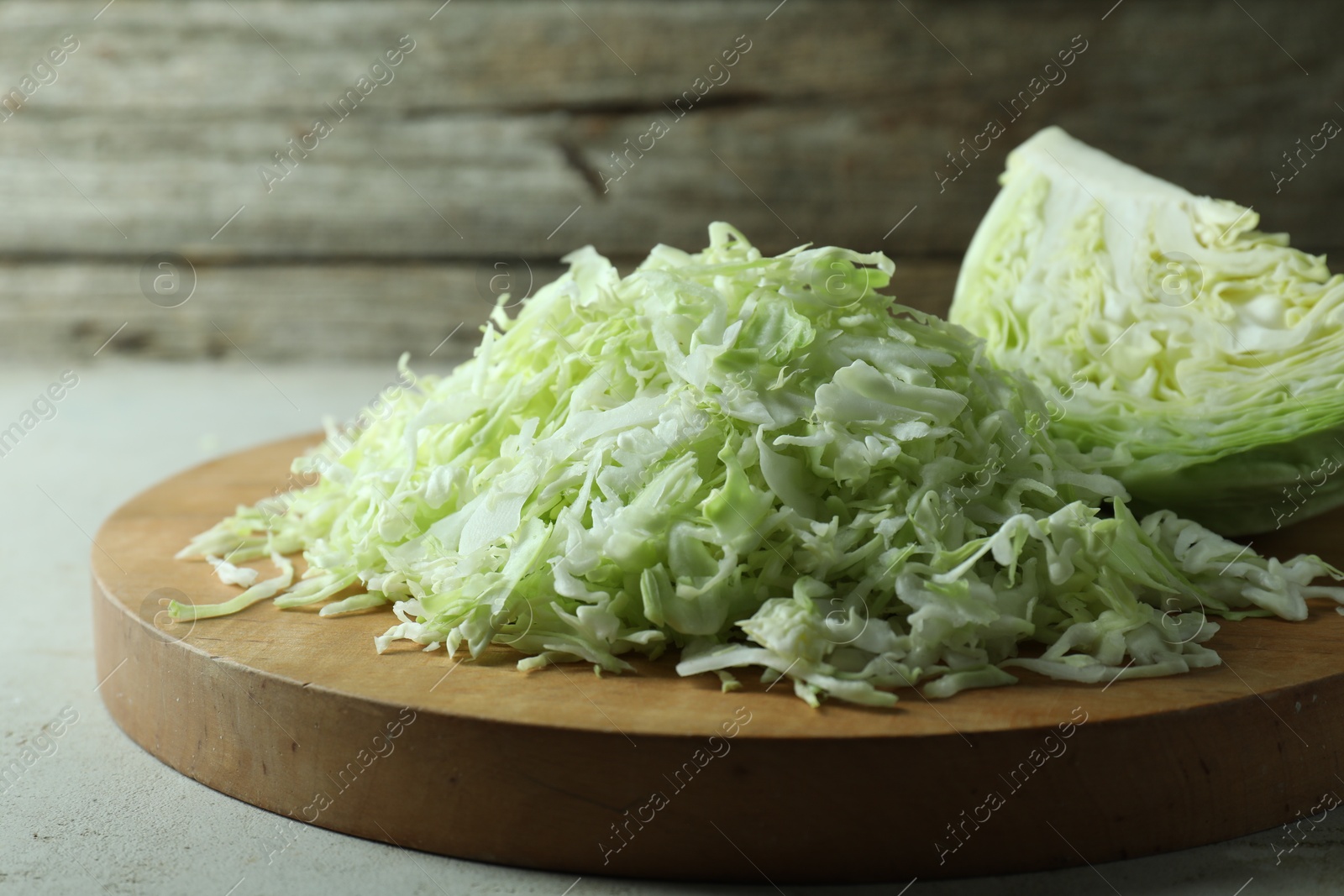 Photo of Fresh shredded cabbage on light table, closeup