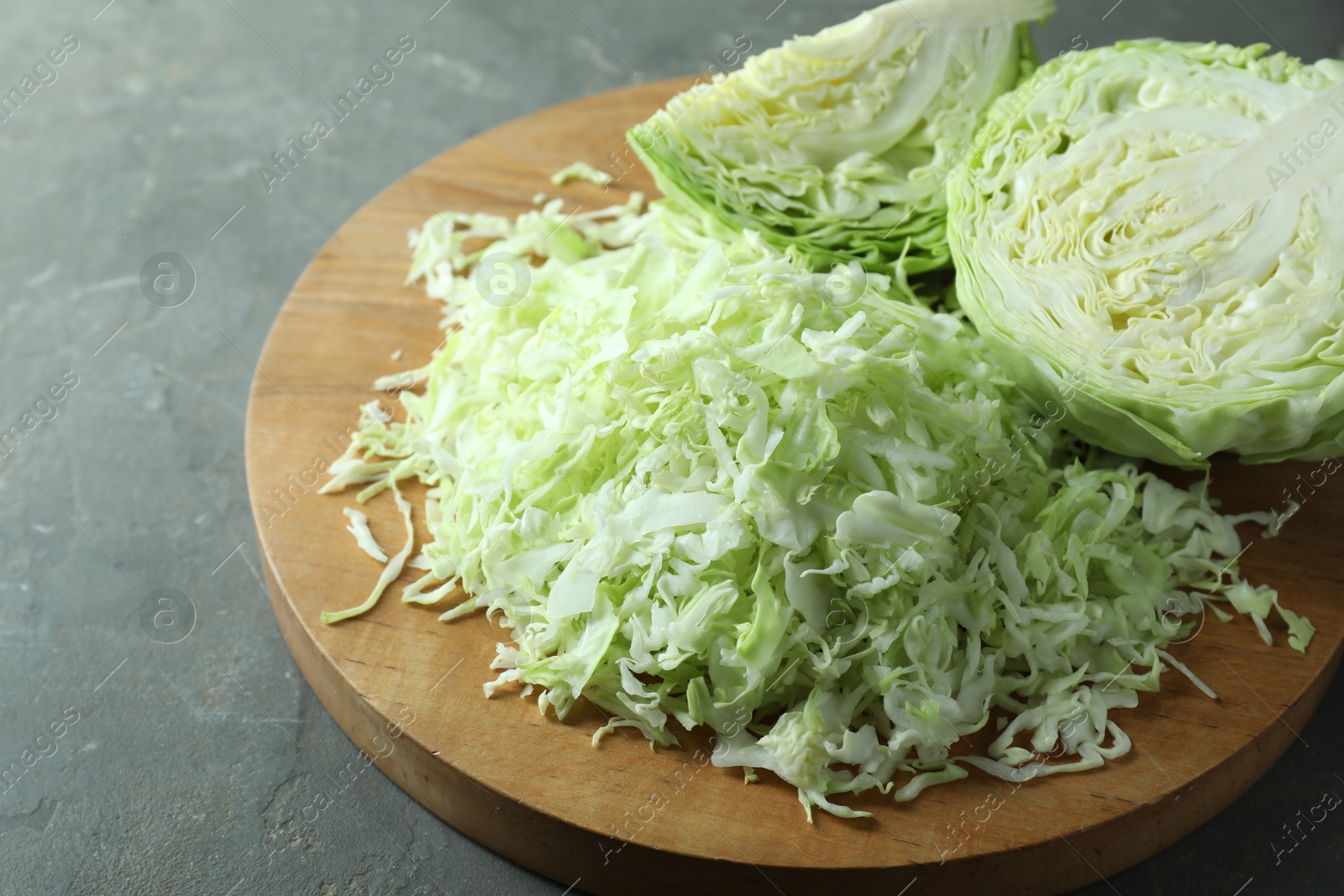 Photo of Fresh shredded cabbage on grey table, closeup