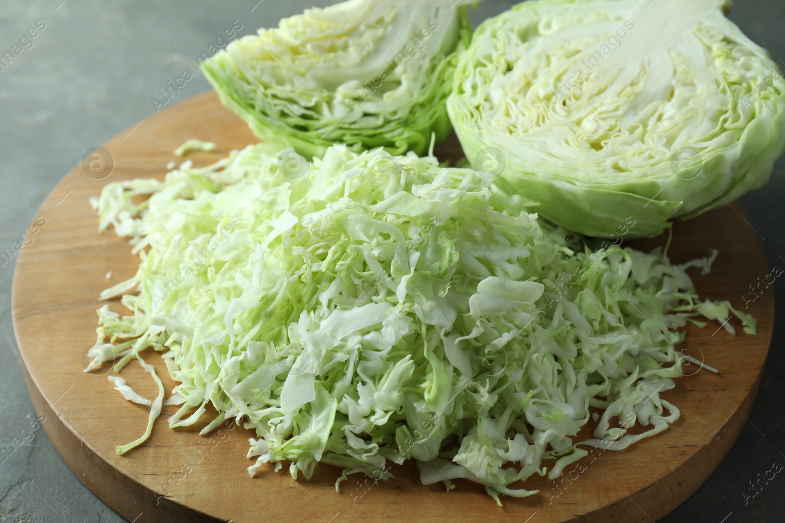 Photo of Fresh shredded cabbage on grey table, closeup