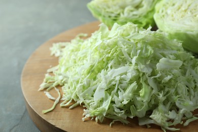 Photo of Fresh shredded cabbage on grey table, closeup