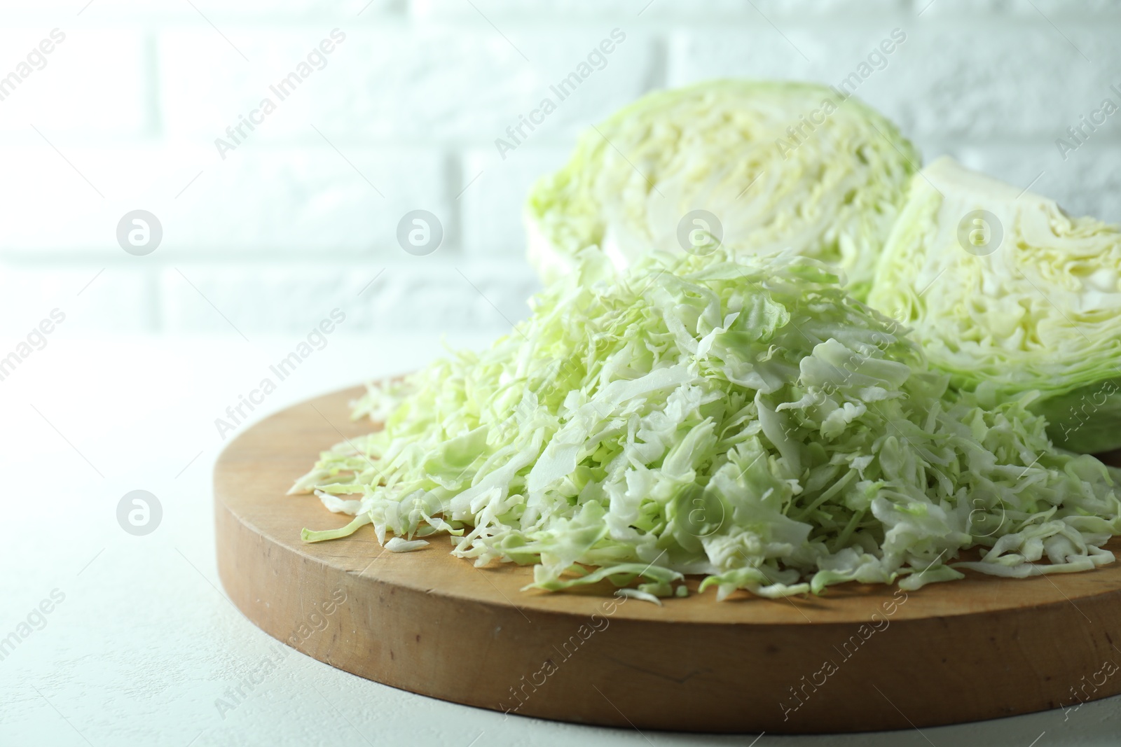 Photo of Fresh shredded cabbage on light table, closeup. Space for text