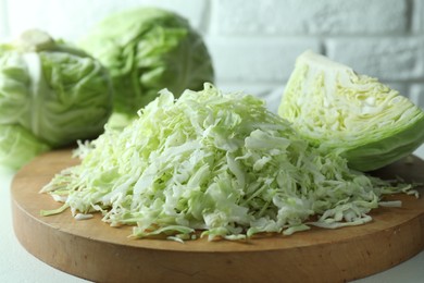 Photo of Fresh shredded cabbage on light table, closeup