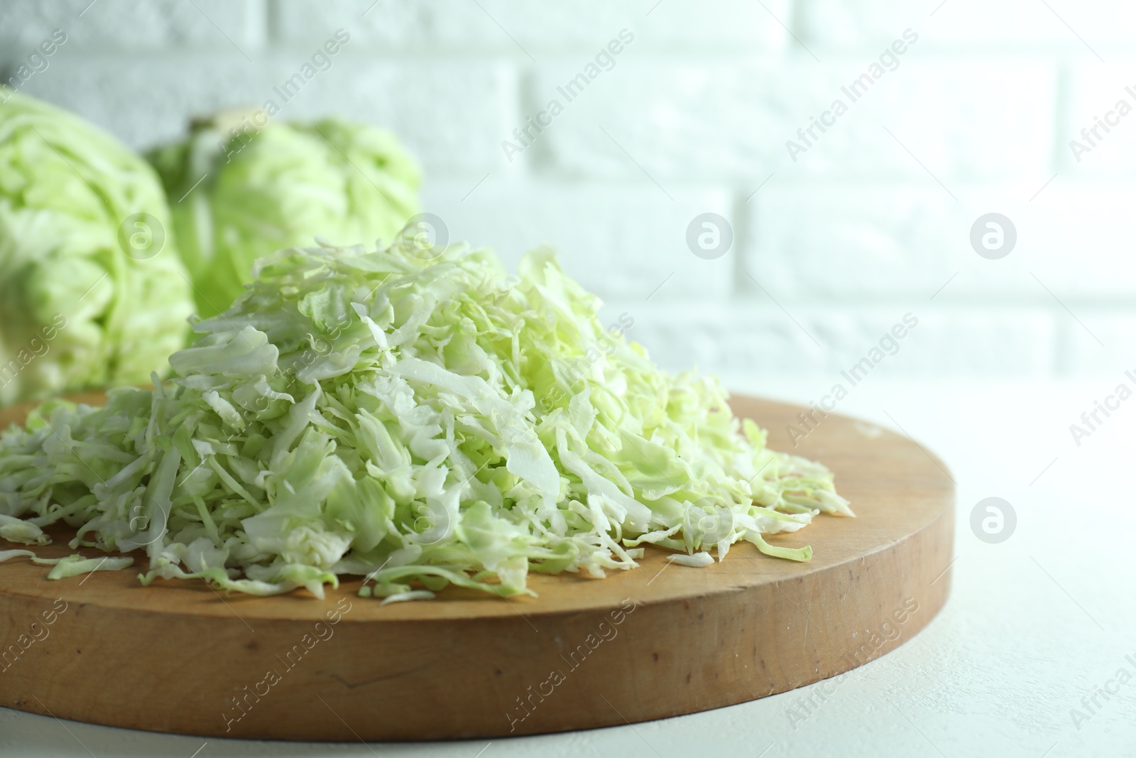 Photo of Fresh shredded cabbage on light table, closeup. Space for text