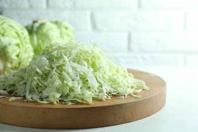 Fresh shredded cabbage on light table, closeup. Space for text