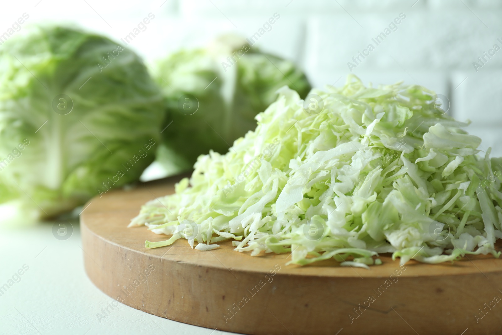 Photo of Fresh shredded cabbage on light table, closeup