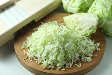 Photo of Fresh shredded cabbage on light table, closeup