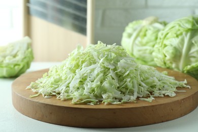 Photo of Fresh shredded cabbage on light table, closeup