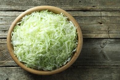 Photo of Fresh shredded cabbage on wooden table, top view