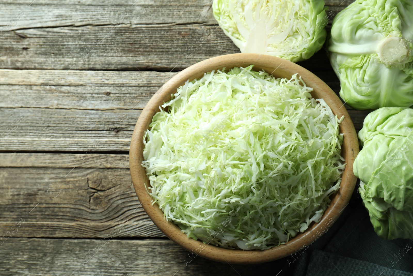 Photo of Fresh shredded cabbage on wooden table, flat lay. Space for text