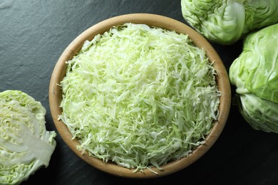 Photo of Fresh shredded cabbage on black table, flat lay