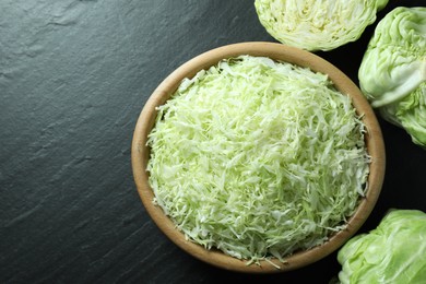 Fresh shredded cabbage on black table, flat lay. Space for text