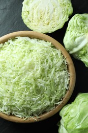 Photo of Fresh shredded cabbage on black table, flat lay