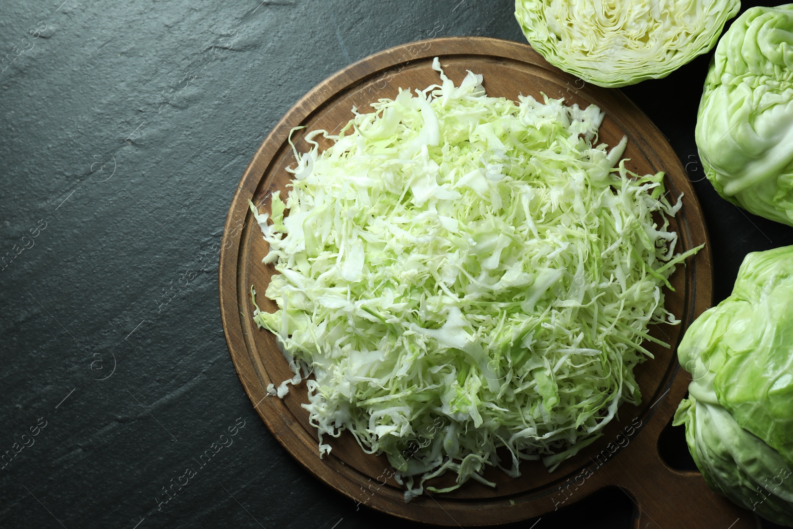 Photo of Fresh shredded cabbage on black table, flat lay