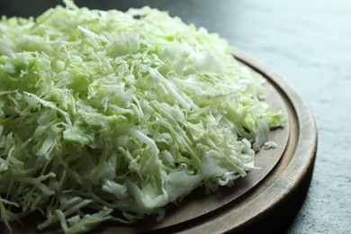 Photo of Fresh shredded cabbage on black table, closeup