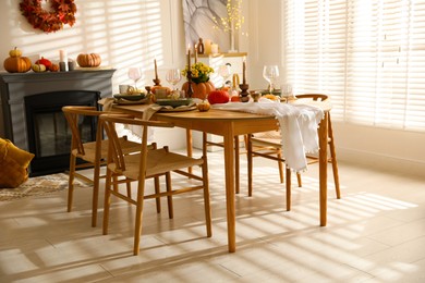 Photo of Stylish dining room with beautiful table setting and autumn decor