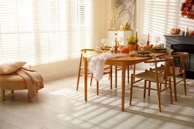 Stylish dining room with beautiful table setting and autumn decor