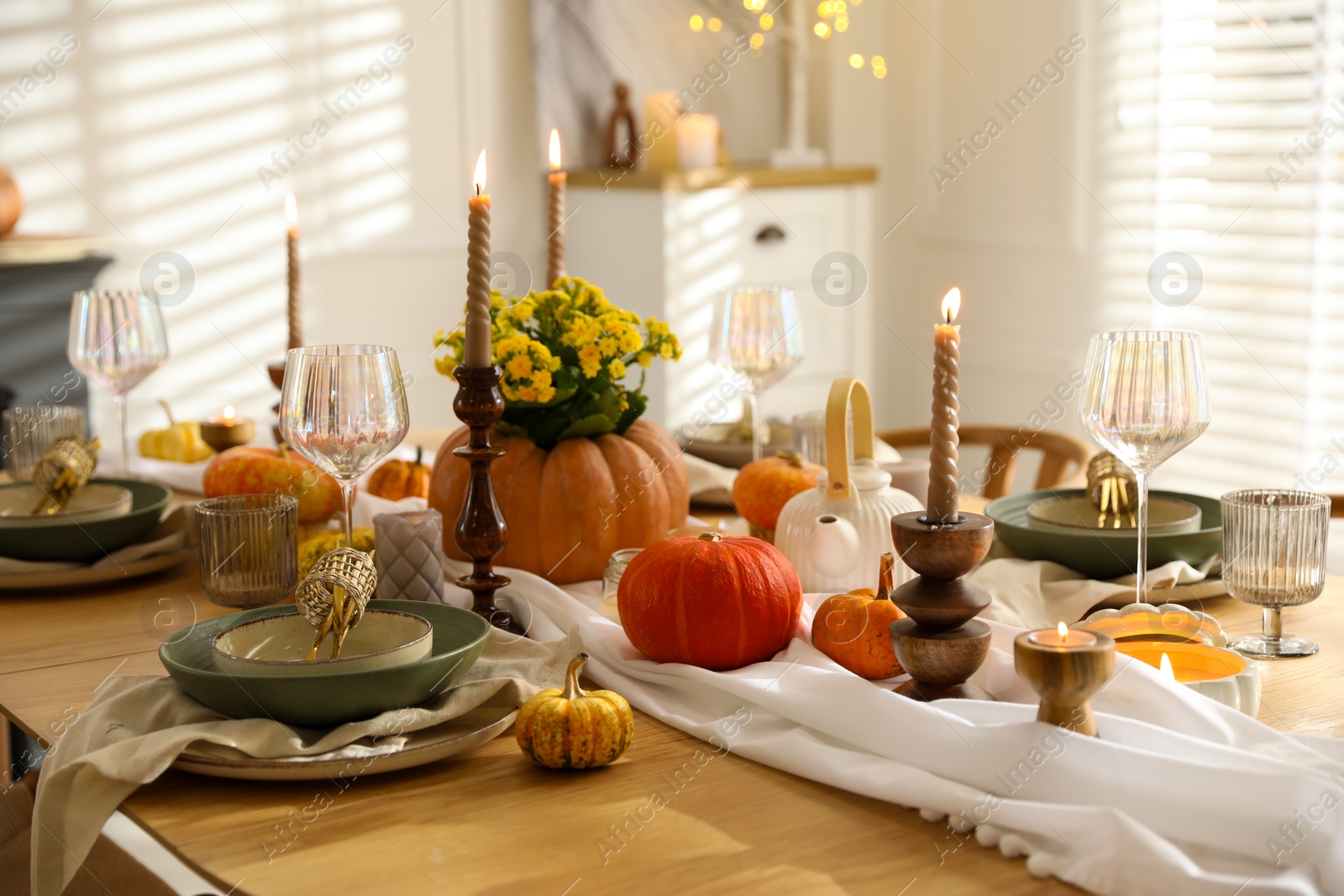 Photo of Stylish table setting with beautiful dishware, glasses and autumn decor in dining room