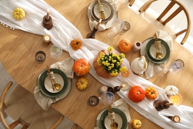 Photo of Stylish table setting with beautiful dishware, glasses and autumn decor in dining room, top view