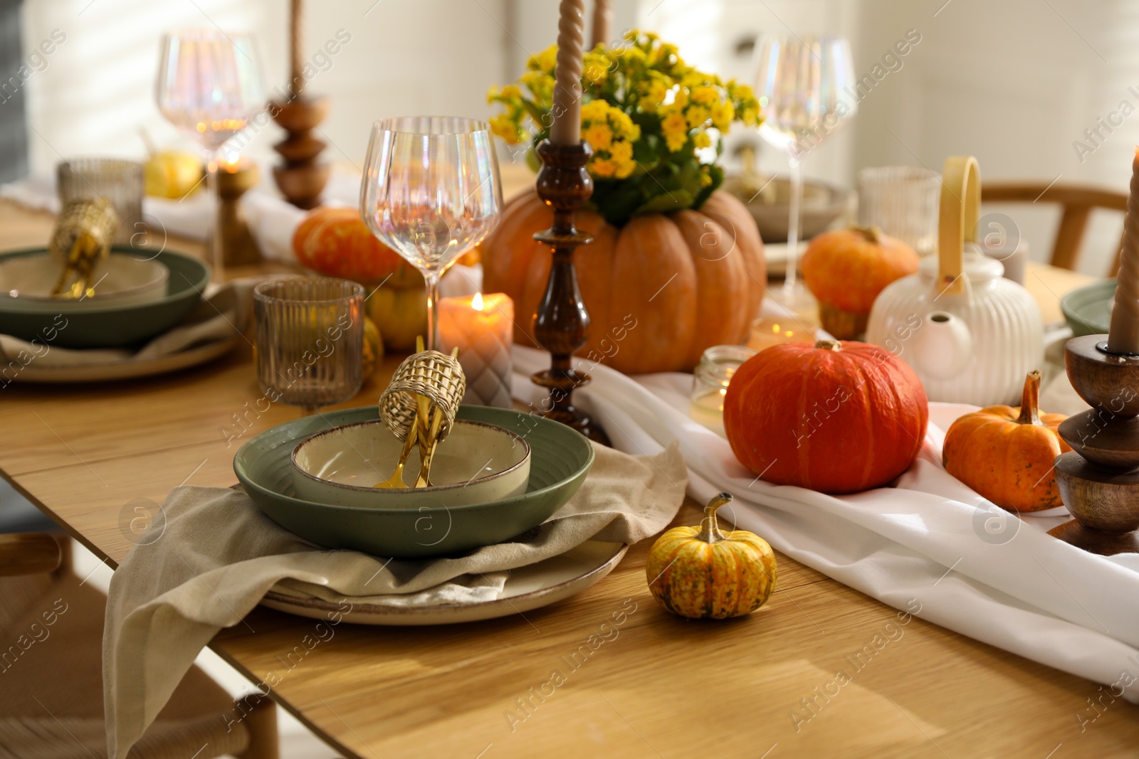 Photo of Stylish table setting with beautiful dishware, glasses and autumn decor in dining room