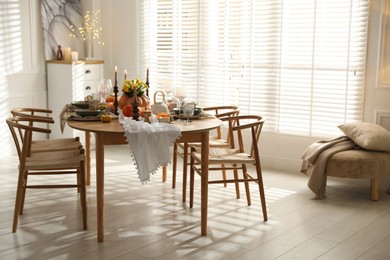 Photo of Stylish dining room with beautiful table setting and autumn decor