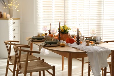 Photo of Stylish dining room with beautiful table setting and autumn decor